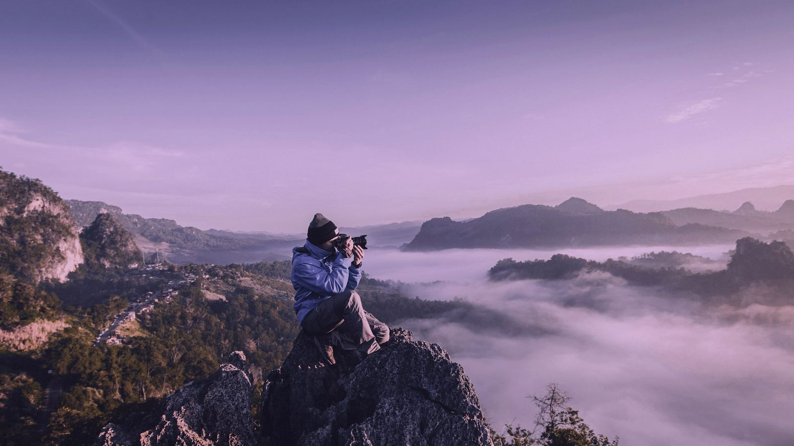 A photographer working from high ground — framing before the shot